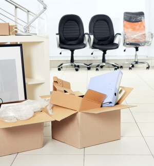 we see two boxes full with office items and three office chairs